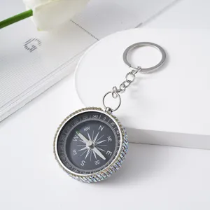 Close-up of a mini aluminum alloy compass keychain decorated with sparkling AB rhinestones