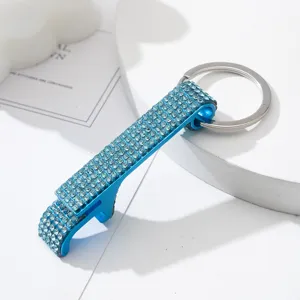 Macro detail of blue rhinestone-encrusted aluminum bottle opener keychain accessory