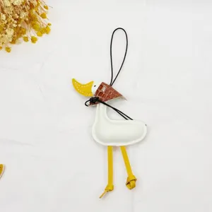 Creative handmade leather duck bag charm with brown scarf detail and long yellow legs