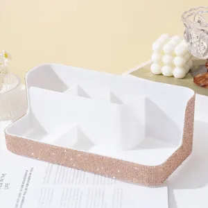 Macro view of white makeup organizer with rose gold rhinestone trim and compartments