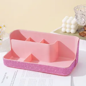 Close-up of pink rhinestone makeup organizer with multiple slots for nail tools.
