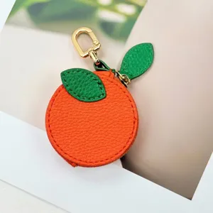 Close-up detail of cute orange-shaped PU leather coin purse with gold metal clasp