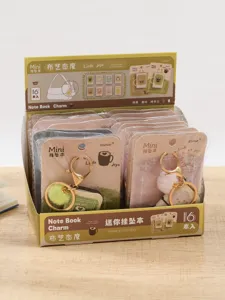 Mini notebook keychain charm set in display box, cute fluffy pom pom pendant detail.