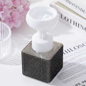 Detailed view of white flower-shaped foam pump on a black rhinestone soap dispenser