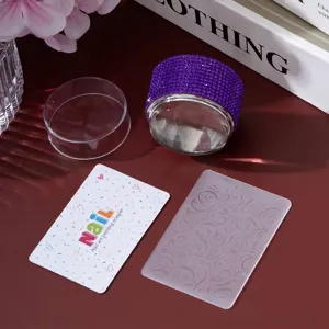 Close-up of purple rhinestone nail stamper with scraper and floral pattern plate