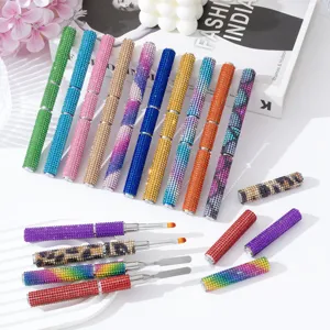 Close-up of rhinestone double-ended nail brushes showing brush tips and metal spatulas