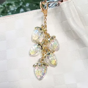 Close-up of iridescent resin strawberry cluster charms on a gold-tone keychain