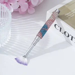 Close-up of fan-shaped nail art brush with a colorful rhinestone studded handle
