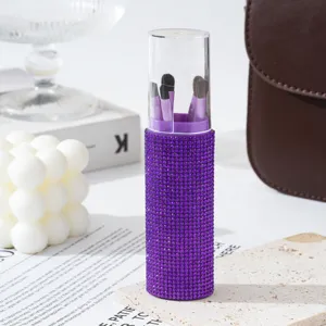 Detail view of purple rhinestone encrusted makeup brush storage tube with five brushes