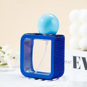 Close-up of a blue rhinestone-encrusted 40ml square portable refillable spray bottle