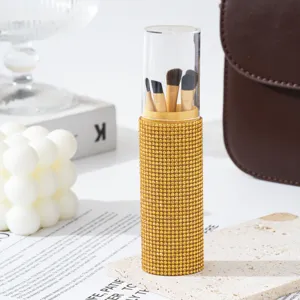 Detailed view of a luxury gold rhinestone makeup brush container with 5 soft pieces.