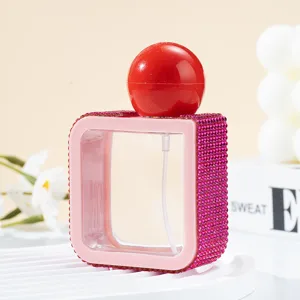 Detailed view of the 40ml square spray bottle with pink rhinestones and a red cap
