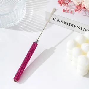 Close-up of pink rhinestone handle on stainless steel nail art mixing spatula tool