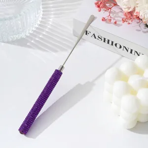 Close-up of professional stainless steel nail art mixing spatula with purple rhinestone handle