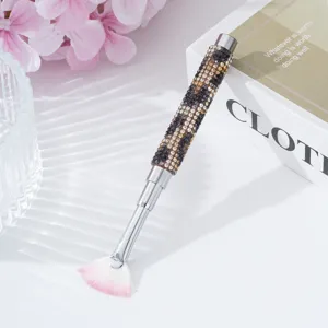 Close-up view of a luxury rhinestone-encrusted fan brush for professional nail art