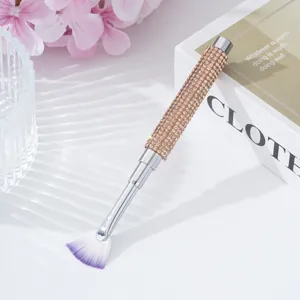 Detailed close-up of a fan-shaped nail art brush with a luxury rhinestone studded handle