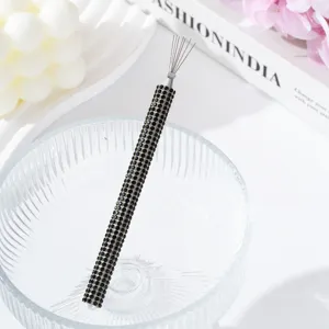 Macro detail of a rhinestone-encrusted nail art tool for spider gel with a black handle.