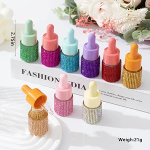 Group of colorful rhinestone-encrusted essential oil dropper bottles in various colors