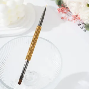 Primer plano de pincel para manicura de doble punta con mango de diamantes ámbar