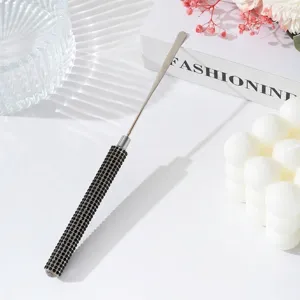 Macro detail of professional stainless steel nail art mixing spatula with black rhinestone handle