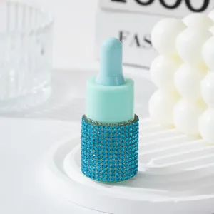 Close-up of blue rhinestone-encrusted essential oil dropper bottle detail