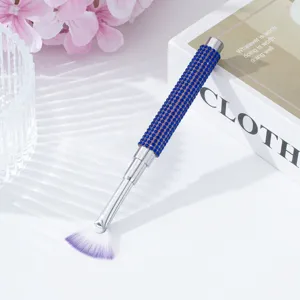 Detail showing the blue rhinestone handle and purple fan-shaped nail art brush head