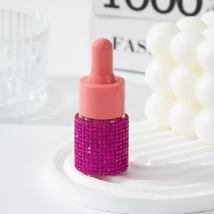 Macro detail of a sparkling pink rhinestone-studded essential oil dropper bottle