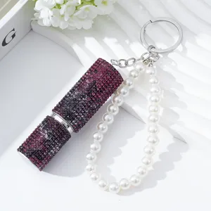 Detail view of a purple rhinestone 5ml perfume atomizer with a pearl wristlet keychain.