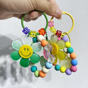 Detailansicht von zwei bunten Sonnenblumen-Schlüsselanhängern mit Smiley-Gesichtern.
