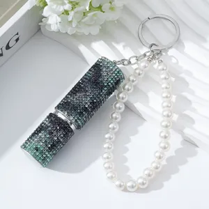 Close-up of a rhinestone-encrusted 5ml perfume bottle keychain with a faux pearl strand.