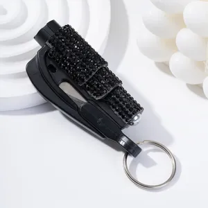 Close-up of black rhinestone-encrusted car window breaker and multi-tool keychain.