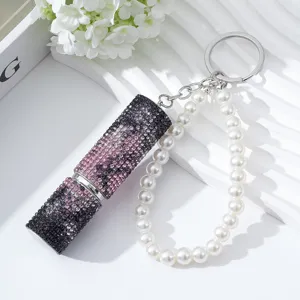 Macro detail of purple rhinestone 5ml perfume atomizer keychain with pearl wrist strap