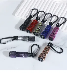 Detailed macro view showing multiple colorful rhinestone mini flashlights with clips