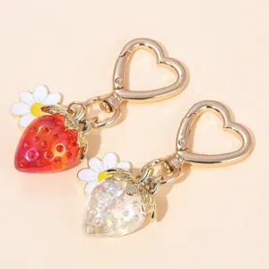 Detailed view of red and translucent strawberry flower keychains with heart clasps