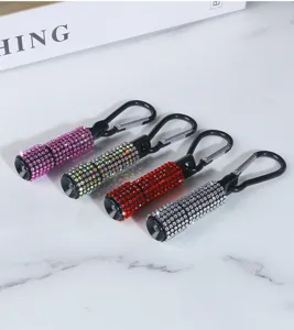 Close-up of four sparkling rhinestone mini flashlights with black carabiner clips