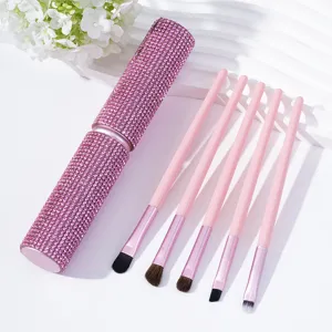 Detailed view of pink rhinestone makeup brush set with five soft brushes and case
