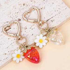 Close-up of translucent red and clear strawberry charms with white daisy flowers