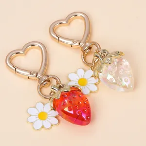Close-up showing the translucent texture of strawberry keychains with heart clasps.