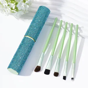 Detail of mint green makeup brush set with a sparkling blue rhinestone travel case