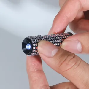 Portable mini flashlight with sparkling rhinestone design shown being held in hand