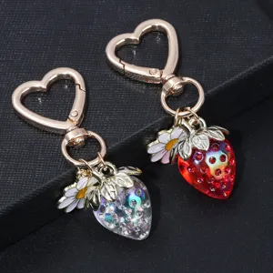 Detailed view of red and iridescent translucent strawberry keychains with heart clasps.