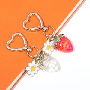 Close-up of sweet translucent strawberry keychains featuring heart clasps and daisy charms