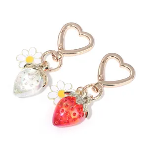 Close-up of translucent strawberry keychains with daisy charms and heart clips