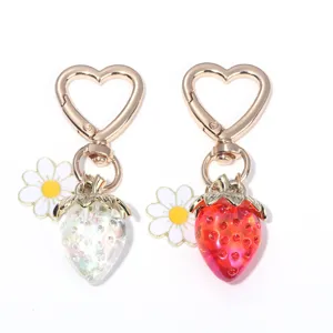 Close-up of cute strawberry and daisy heart-shaped keychains in red and white