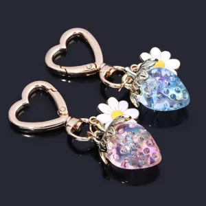 Detailed view of translucent strawberry keychains with rhinestones and heart clasp
