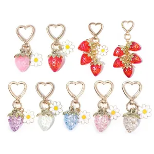 Collection of translucent colorful strawberry and daisy keychains with heart-shaped clasps