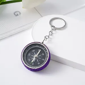 Detailed close-up showing purple rhinestone encrusted mini compass keychain for outdoor use