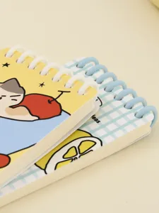 Detailed macro view of A7 spiral notebooks featuring cute cartoon cat and lemon cover art