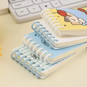 Stack of premium portable A7 7-hole loose-leaf coil notebooks with cute cartoon covers