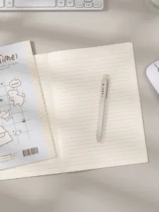 Gedetailleerd overzicht van het minimalistische gelinieerde notitieboekje met pen op bureau.